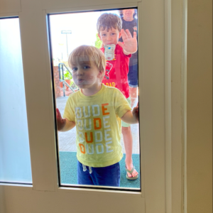Dublin Visitors Center- Little boy in yellow shirt kisses window while little boy in red waves