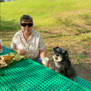 Dublin Visitors Center- Woman and dog sit at green picnic table