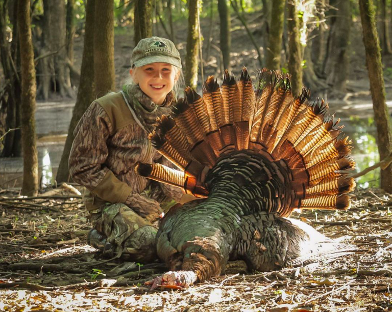 Young girl poses with her catch during turkey hunting season